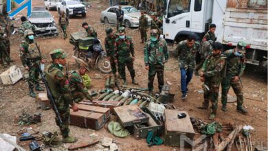 TNLA soldiers examine weapons and ammunition seized at the junta’s Sakhan Thit hill base in Namkham Township, which the group captured on December 18 (Myat Pan/Myanmar Now)