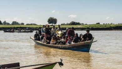 Displaced residents cross a river to safety after fleeing fighting in Bhamo in December 2024 (Photo: AFP)